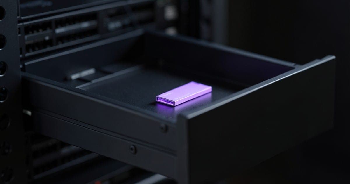 An open server drawer with a single memory module glowing violet