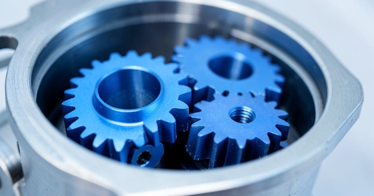 Precision blue metal gears meshing inside a mechanical gearbox